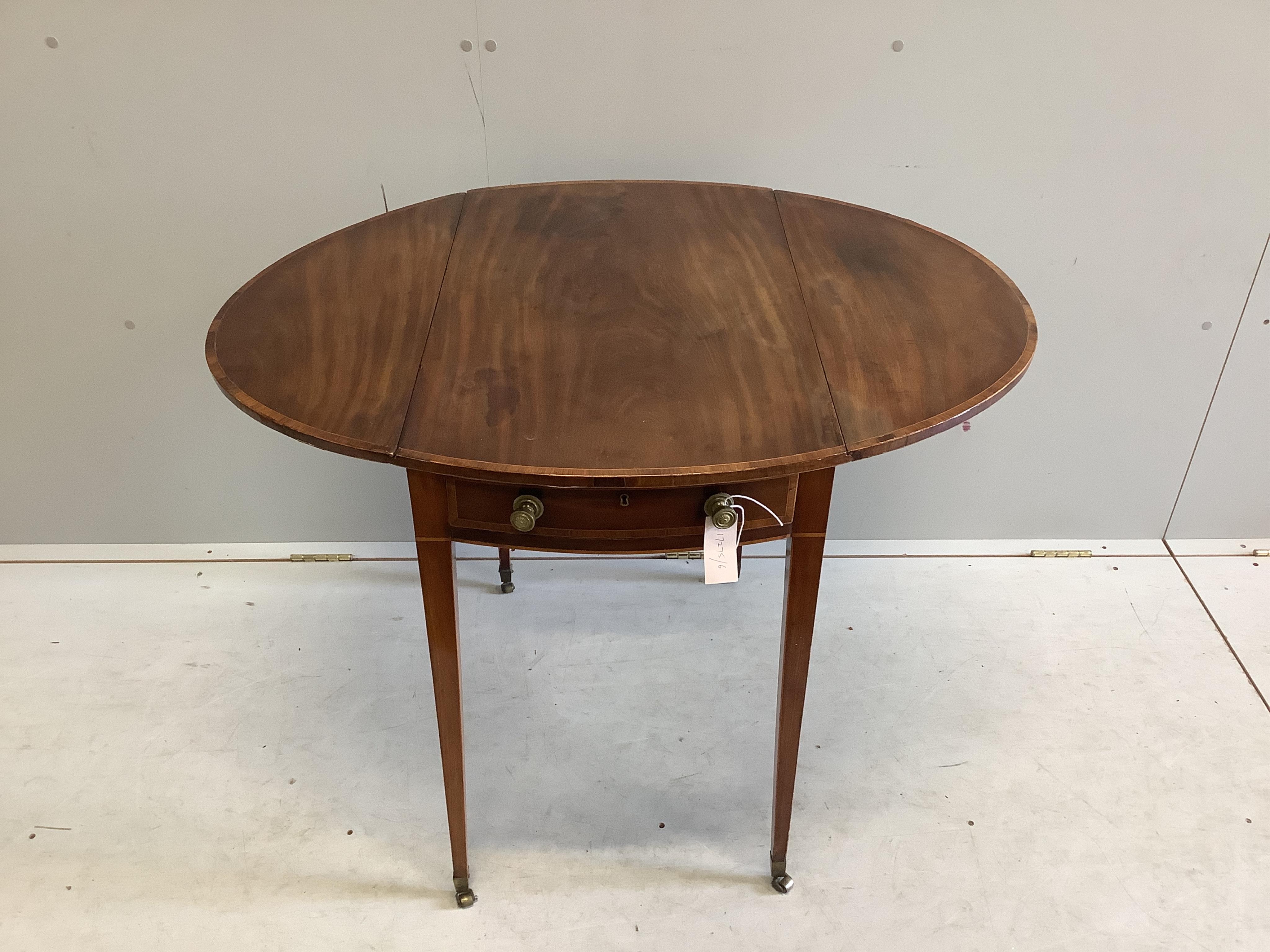 A late Georgian oval banded mahogany Pembroke table on square tapering legs on brass castors, width 46cm, depth 74cm, height 72cm. Condition - fair